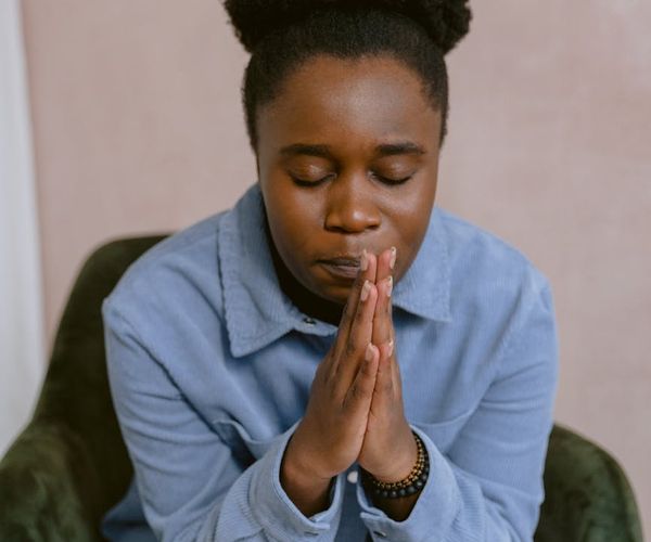 Close-up of a person's hands in a prayer pose, symbolizing mindfulness.